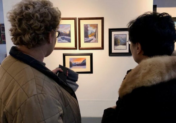 With Vernissage XVIII, RIVAA Returns In Style Pastelist Georgette Sinclair (R) discusses her latest work with a visitor.